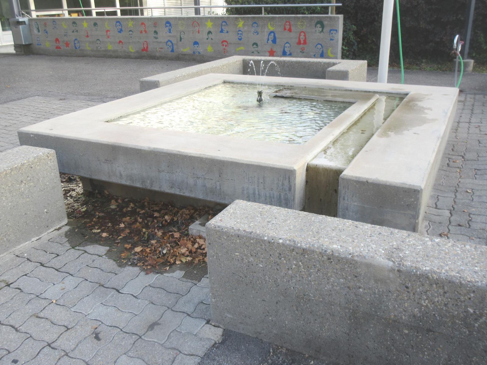 Schulzentrum Hinterbüel - Pausenplatz *** o.J. (1. Bauetappe 1955-59) *** Beton, buntes Mosaik am Beckenboden *** Messingspeier, dreiröhrig *** --